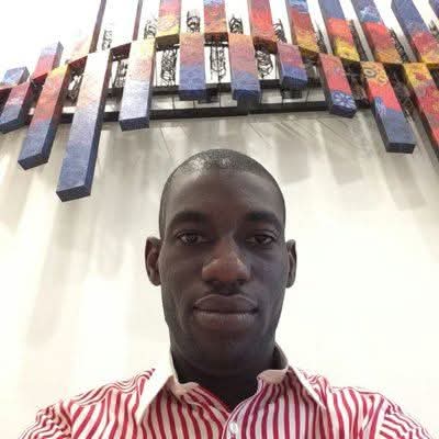 Taiwo Odeyemi smiling in a striped shirt
